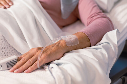 Close up of senior caucasian female patient lying in hospital bed with pulse oximeter