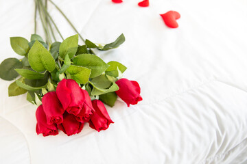 Rose on  white bed honeymoon suit.Valentine's day concept. Beautiful blurry background.heart lay on the bed.