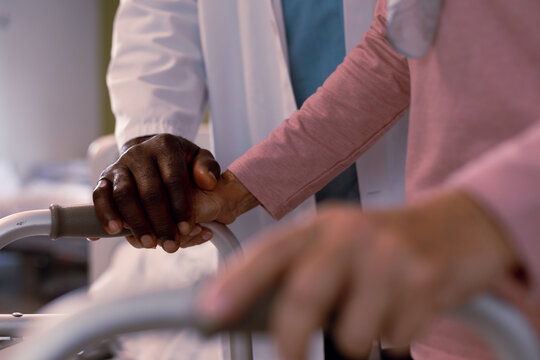 Close up of african american doctor and senior caucasian patient holding hands