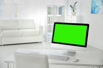 Computer display with chroma key on desk indoors. Comfortable workplace