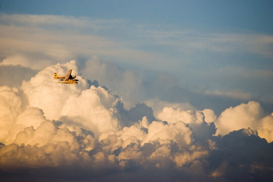Small float plane over thunderhead clouds, Montana
