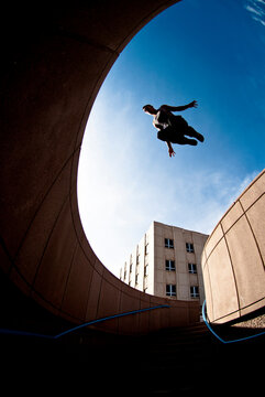 An athletic young man jumps while practicing parkour in Albuquerque, New Mexico.