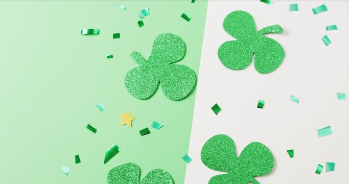 Video of st patrick's green shamrock leaves with copy space on green to white background