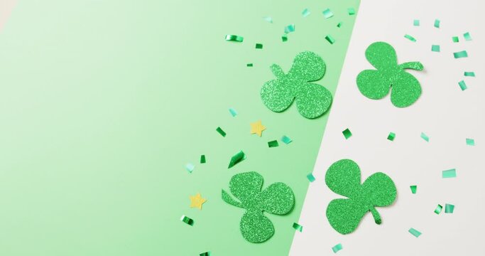 Video of st patrick's green shamrock leaves with copy space on green to white background
