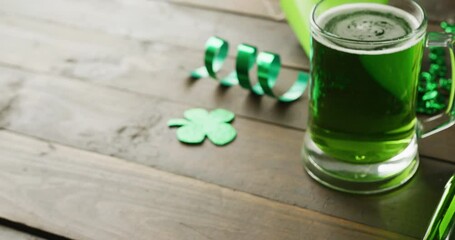 Video of st patrick's green shamrock and green beer with copy space on wooden background