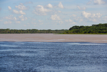The confluence of the dark waters of the Guaporé-Itenez river with the sand-colored waters of the Mamoré river, near the small village of Surpresa, Rondonia state, Brazil, on the border with Bolivia
