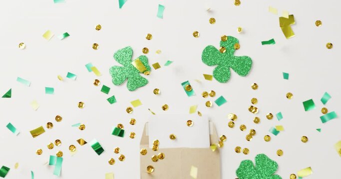 Video of st patrick's green shamrock, letter and sequins on white background