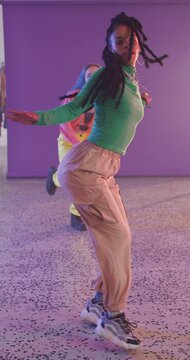 Vertical video of portrait of happy diverse female dancers dancing in dance studio