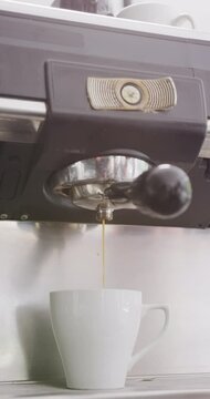 Vertical video of close up of working coffee machine making coffee in cafe