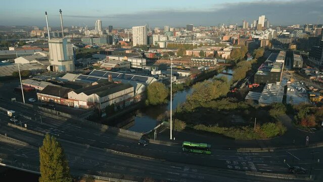 Establishing Shot of A61 Road on Outskirts of Leeds City Centre with Green Bus and Glass Bottle Factory with Chimneys at Morning Sunrise in West Yorkshire UK