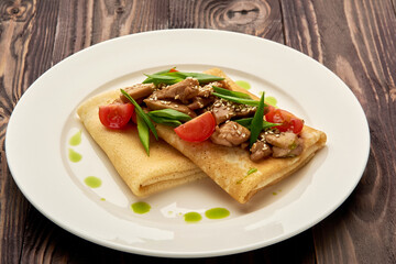 juicy pancakes with meat and tomatoes on a white plate