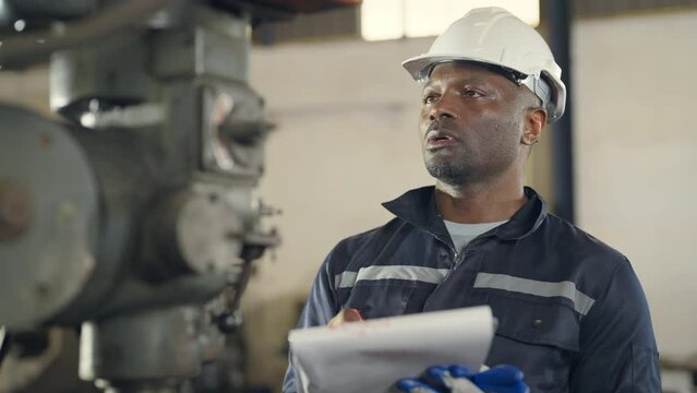Male engineer examining and maintenance machine at lathe factory, worker or technician check and maintenance metal with professional, industry and machinery concept.