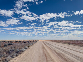 Outback desert dirt road with blue sky, South Australia.