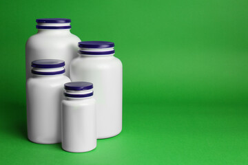 Many different plastic medicine bottles on green background, space for text. Medicament
