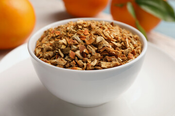 Bowl of dried orange zest seasoning and fresh fruits on plate