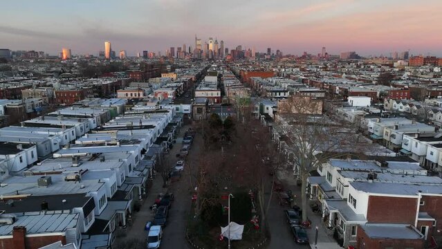 Aerial flight over Smedley Street with Philadelphia skyline in background. Festive Philly neighborhood decorated for Christmas. Tilt down.