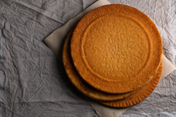 Delicious homemade sponge cakes on grey tablecloth, top view. Space for text