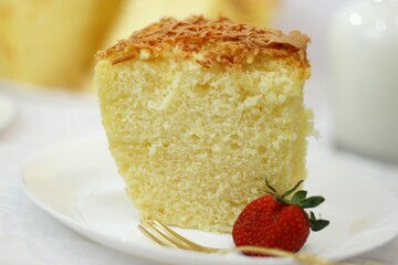a piece of sponge cake with strawberries on a white plate. soft and delicious cheese cake. homemade bakery concept for background or wallpaper.