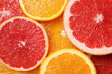 Slices of grapefruit and orange as background, top view