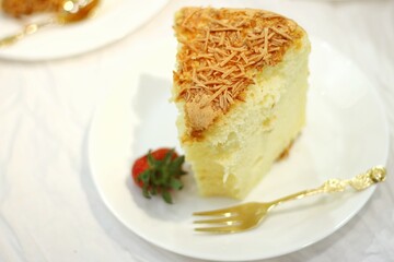 a piece of sponge cake with strawberries on a white plate. soft and delicious cheese cake. homemade bakery concept for background or wallpaper.