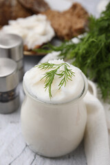 Delicious pork lard with dill in glass jar on light textured table, closeup