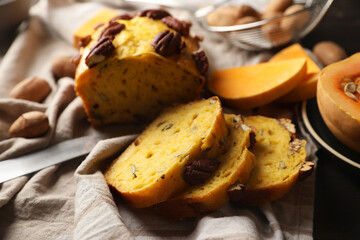 Delicious pumpkin bread with pecan nuts on tablecloth, closeup