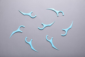Flat lay composition with dental floss picks on grey background