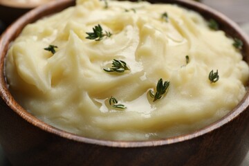 Bowl of delicious mashed potato with thyme, closeup
