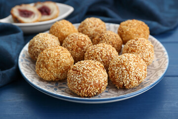 Delicious sesame balls on blue wooden table, closeup