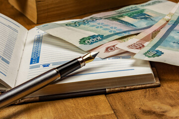 On the open diary page there are several monetary denominations and a fountain pen