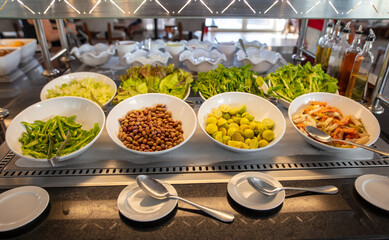 Vegetables with greens in plates on display in the dining room.