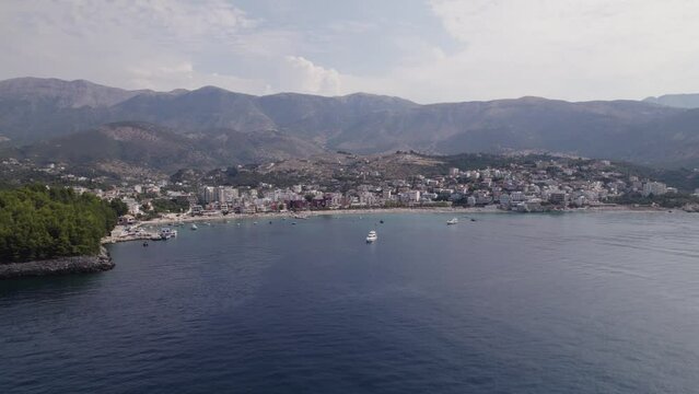 Aerial View Of Spile Beach Coastline With Mountains In Background. Slow Orbit Motion Over Ionian Sea, Establishing Shot