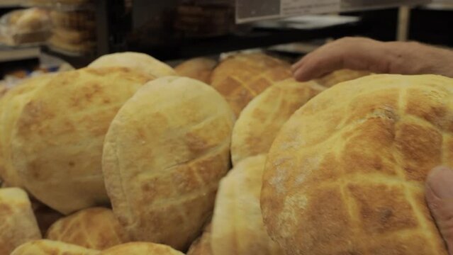 Man putting bread bun on a pile