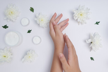 Moisturizing care skincare face cream for healing complicated troubled skin type. girl smears her hands cosmetic cream. skin care, elastic and young skin of the hands. flat lay, top view.