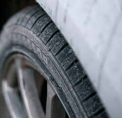 Close-up of car wheels rubber tires in winter snow. Concept of transportation and safety during the winter season. Selective focus.