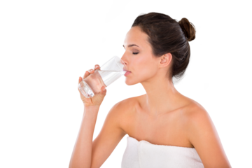 Side view of a beautiful young woman wrapped in a towel and drinking a glass of water with her eyes closed Isolated on a PNG background.