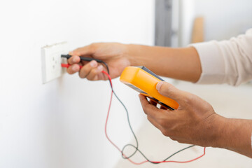 close up electrician engineer hand hold multimeter to use about measure voltage or ampere current in industry factory for system control and technical maintenance concept