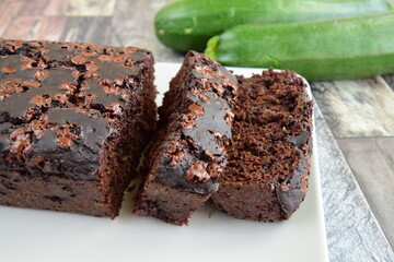 Zucchini chocolate cake. Moist double chocolate cake with grated zucchini, cocoa powder, chocolate and chocolate chips. Shot on wooden background