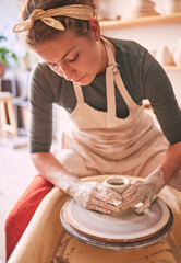 Woman, sculpture artist and mud wheel for clay design, creative manufacturing and expert focus in studio workshop. Female, pottery process and small business designer working with ceramic craft