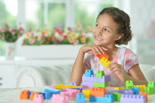 little girl playing with colorful plastic blocks