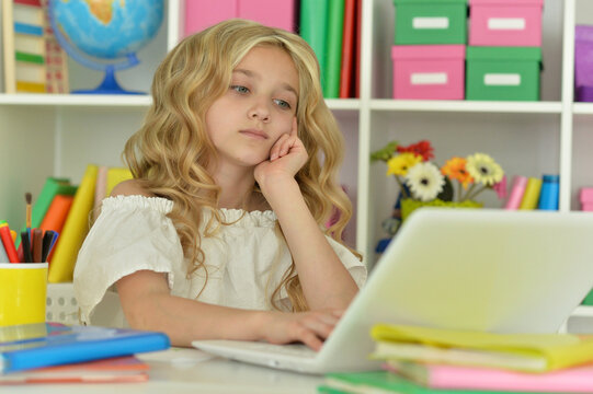 girl using laptop at desk at home