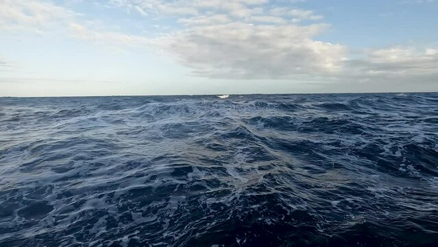 Caribbean blue ocean at sea level splash underwater slow. Destination vacation travel tropical ocean sea. Caribbean cruise ship wake boat. Beautiful blue Caribbean Ocean water. Vacation.
