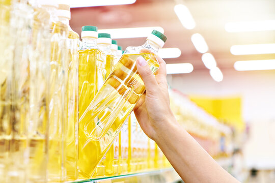 Hand with sunflower oil in store