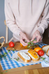 Age woman preparing healthy sandwiches with microgreens and vegetables