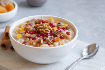 Traditional Turkish delicious mixed dessert, ashura (asure) with pomegranate seeds, walnut,...