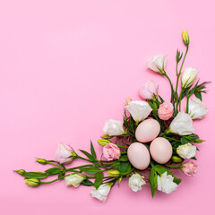 Easter background with Easter eggs and spring flowers. Top view with copy space. Nest with eggs decorated with beautiful flowers on a pink background.