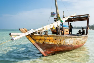 Photo sur Plexiglas Plage de Nungwi, Tanzanie Wooden fisherman boats on sandy beach with blue water background, Zanzibar, Tanzania