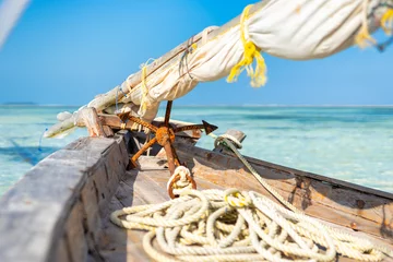 Crédence de cuisine en verre imprimé Plage de Nungwi, Tanzanie Wooden fisherman boats on sandy beach with blue water background, Zanzibar, Tanzania