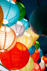 Close focus on colorful globe paper lamps decorated under roof.