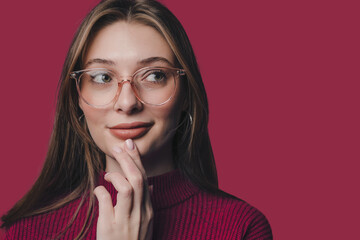 Portrait of positive woman wearing eyeglasses thinking about perfect weekend touch chin with hands isolated over crimson color background